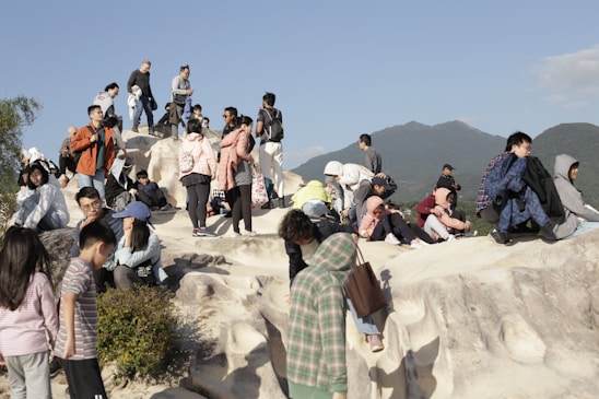 A diverse group of people standing united on a shared landscape under a clear sky.
