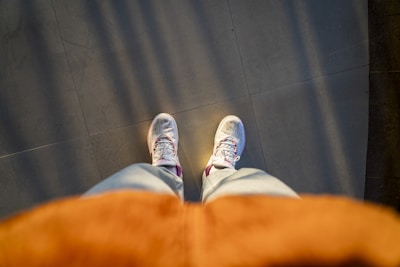 A casual outfit featuring a cream-colored long sleeve tee and loose khaki pants, styled with white sneakers on a sunlit patio.