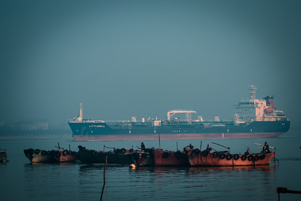 a large cargo ship in the water next to other boats