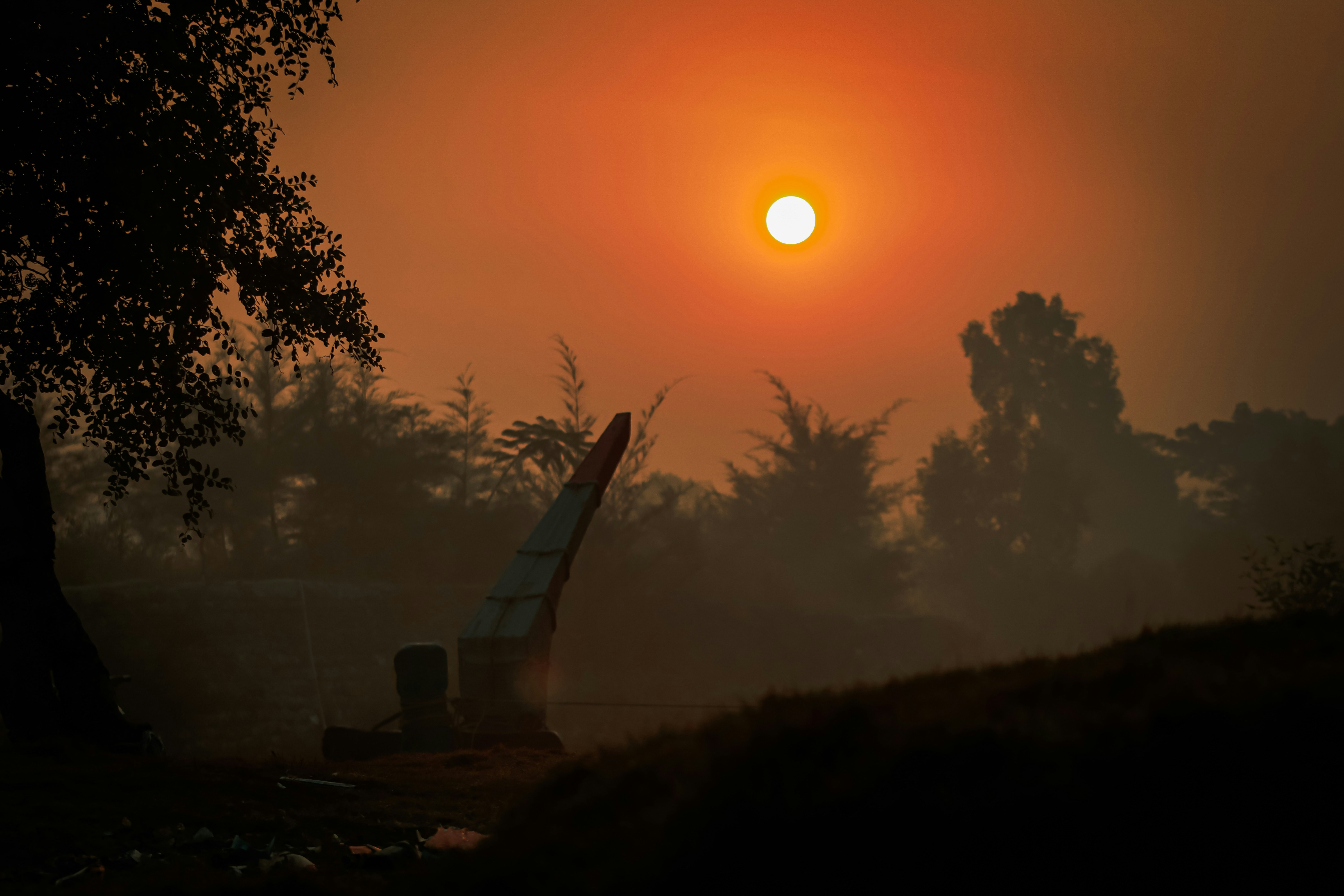 the sun is setting in the sky over a field