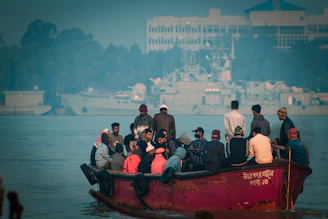 a group of people riding on the back of a red boat