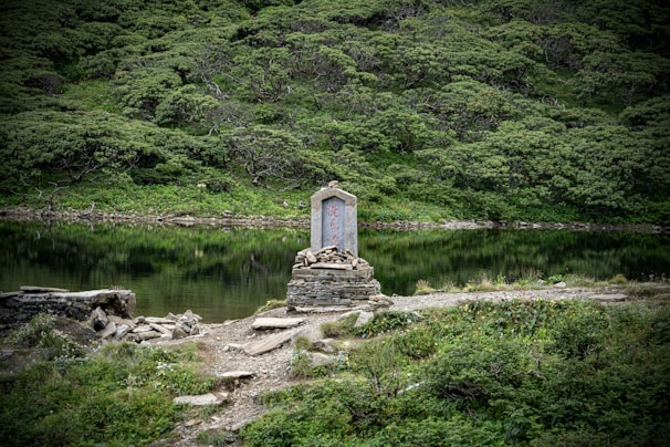 A serene landscape with a memorial statue in the foreground.