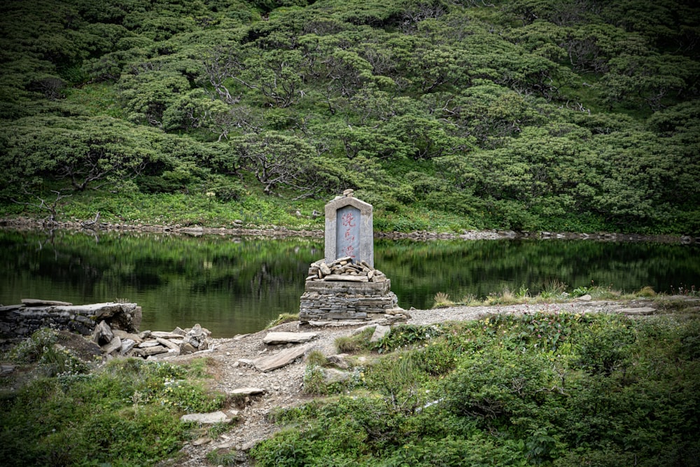 a stone monument sitting on top of a lush green hillside