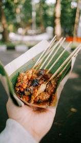A vibrant plate of Indonesian satay skewers garnished with fresh herbs and spices.