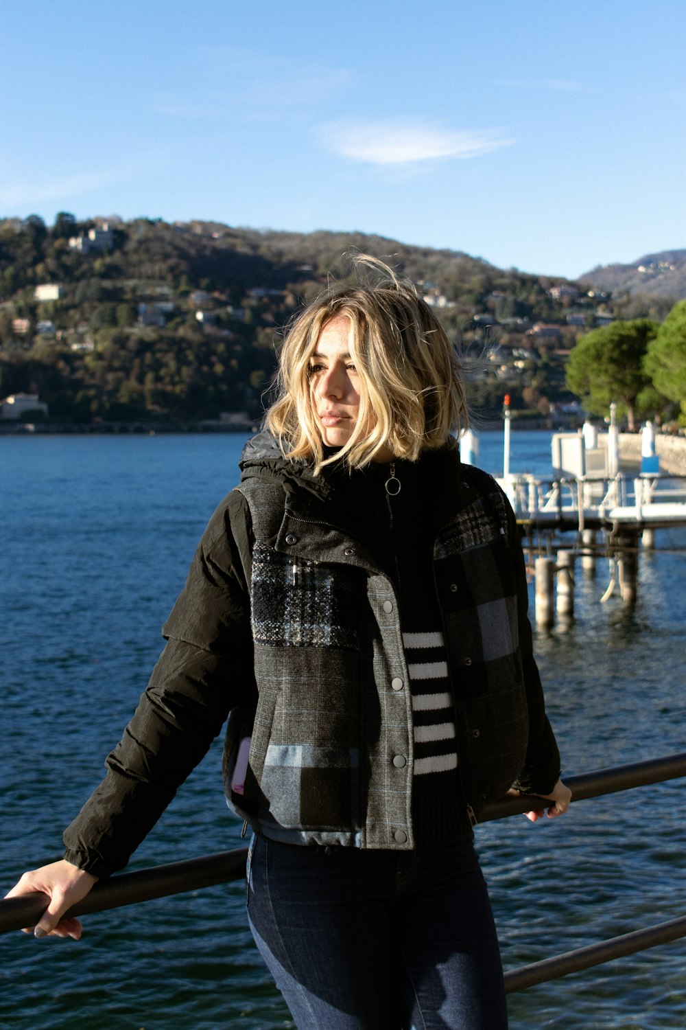 a woman standing next to a railing near a body of water