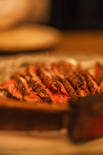 Close-up of a beautifully plated carabeef steak with wood textures and soft lighting.