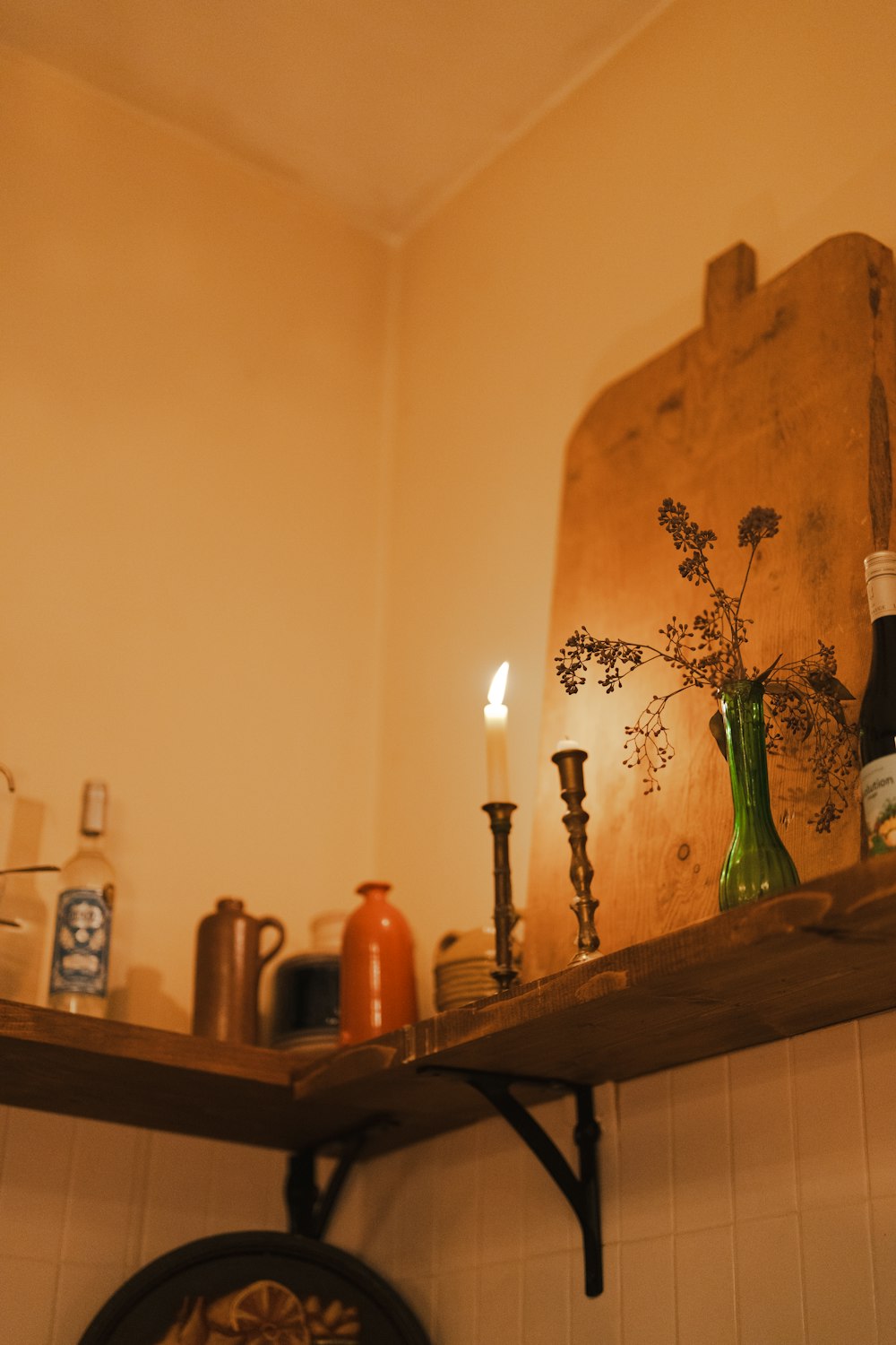 a shelf with candles, bottles, and other items on it