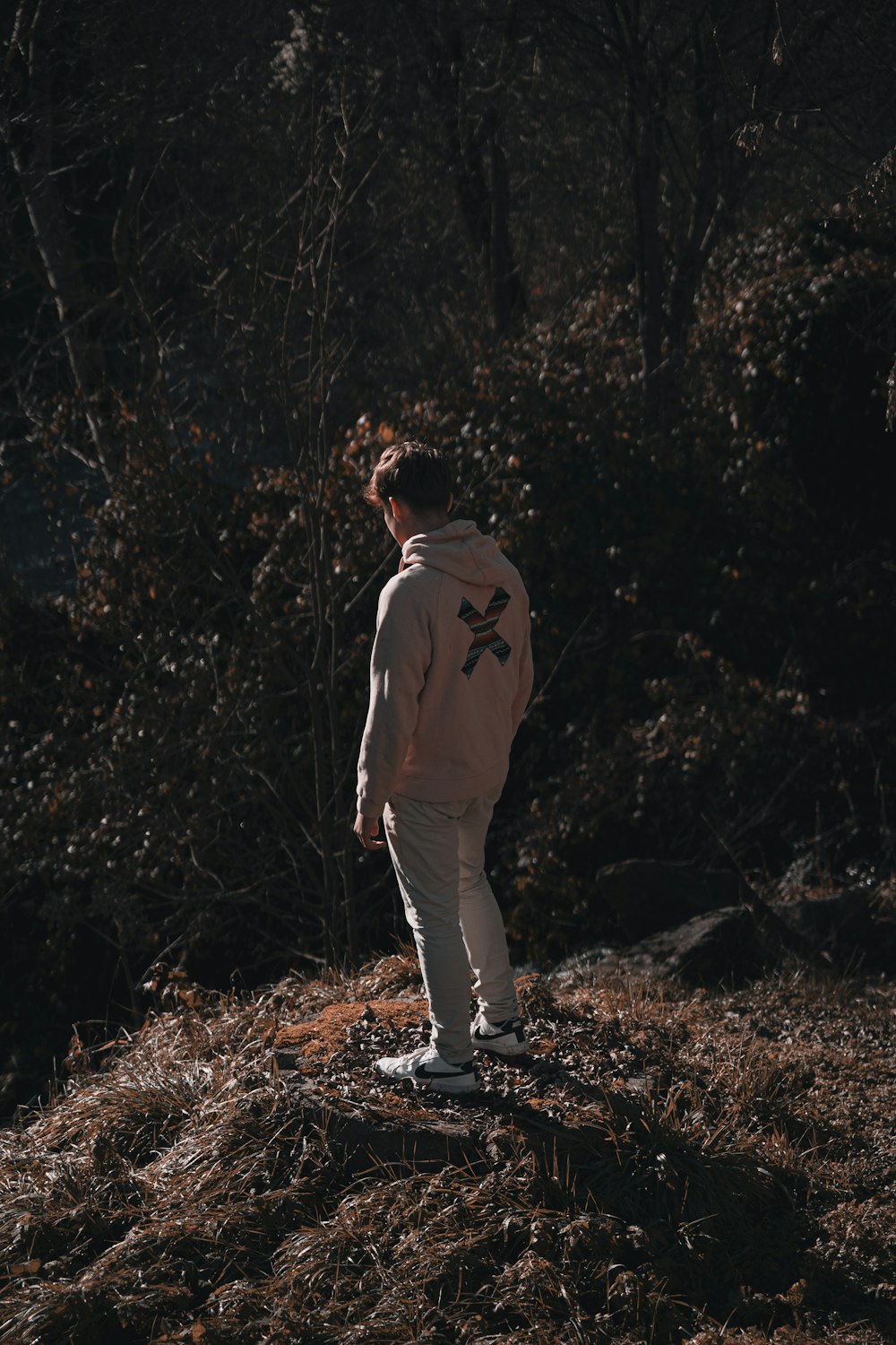 a man standing on top of a grass covered hillside