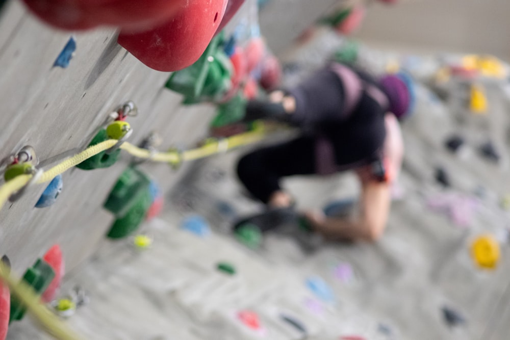 a person climbing up the side of a climbing wall