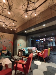 Cozy and welcoming common area of Georgeshousesmani with warm lighting and comfortable seating.