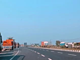 Wide view of the bitrem access road with trucks lined up under a clear sky.