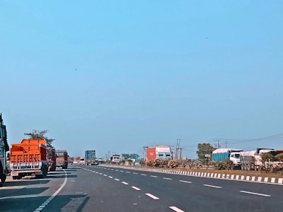 Fleet of trucks on the highway under a clear sky, symbolizing efficient route planning.