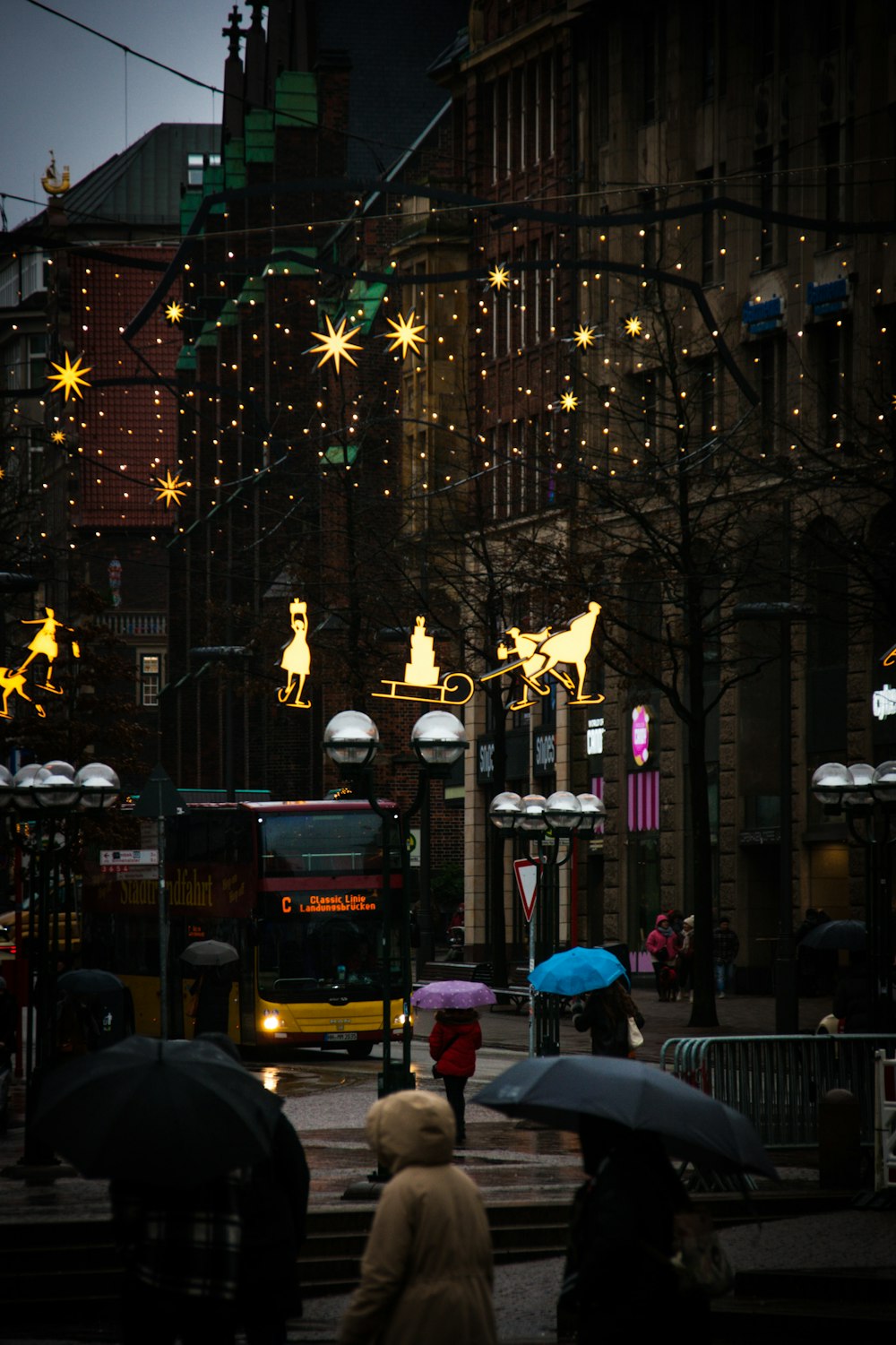 a group of people walking down a street holding umbrellas