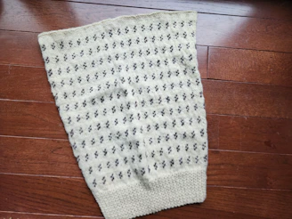 Close-up of hand-drafted pattern pieces laid out on natural cream fabric.