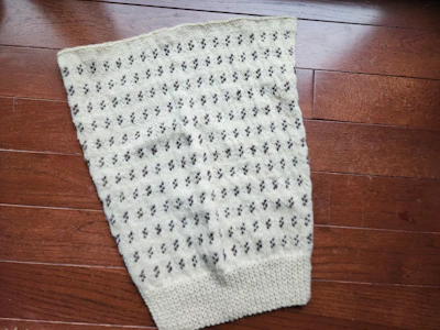 Close-up of hand-drafted pattern pieces laid out on natural cream fabric.