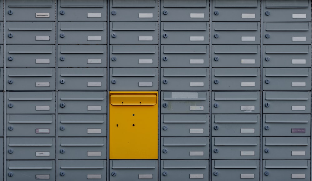 a bunch of mail boxes with a yellow door