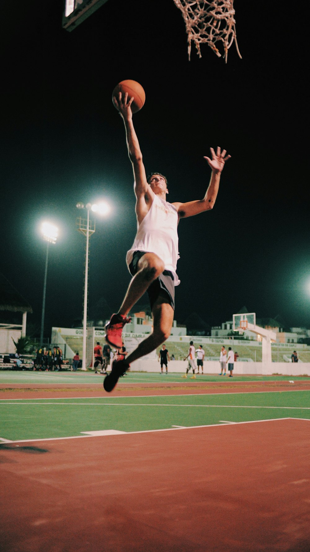 Un hombre saltando en el aire para encestar una pelota de baloncesto