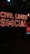 A vibrant neon sign with the words 'Civil Lines Social' is illuminated in bold red letters against a dark background. Below the sign, there are large ornate plant pots with greenery, and a digital screen displaying a message. The ambiance is modern and urban with a nightlife vibe.