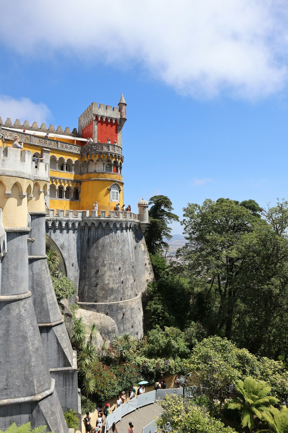 a castle on top of a hill with people walking around