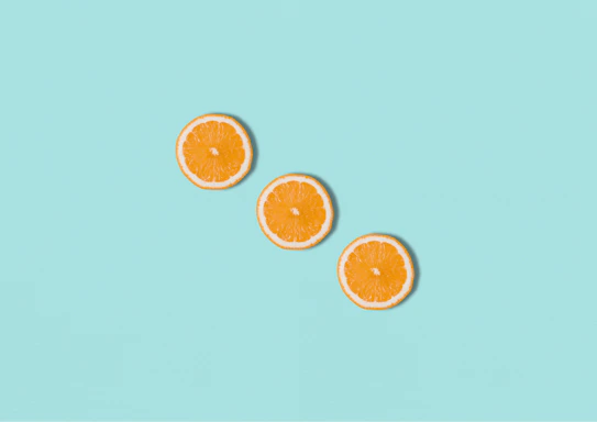 three slices of orange sitting on top of a blue surface