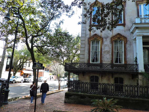A friendly portrait of Gordon standing in front of a charming Savannah neighborhood.