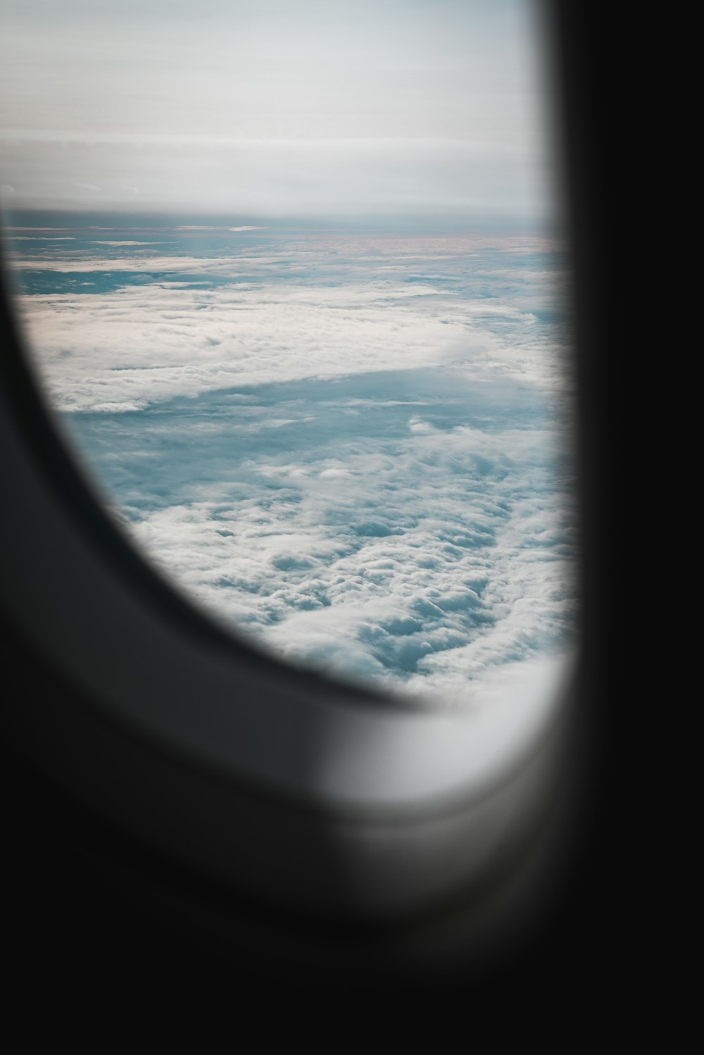 an airplane window with a view of the sky and clouds