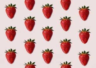 a group of strawberries on a pink background
