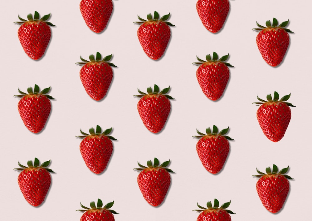 a group of strawberries on a pink background