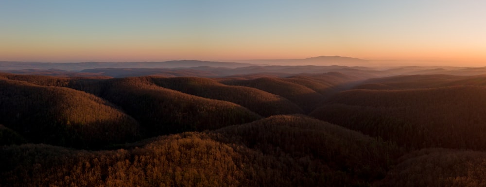 the sun is setting over a mountain range