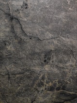 A serene, monochromatic palette of deep charcoal and soft slate blending seamlessly on a textured surface.