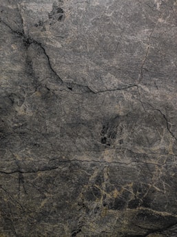 A serene, monochromatic palette of deep charcoal and soft slate blending seamlessly on a textured surface.