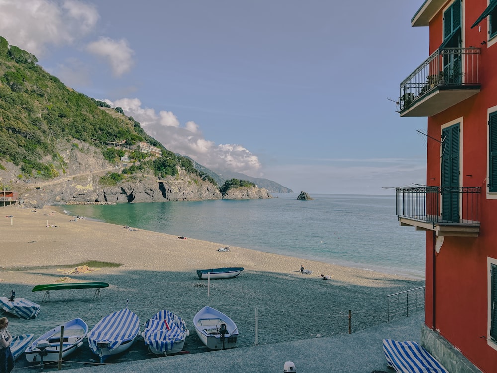 a beach with a red building next to a body of water