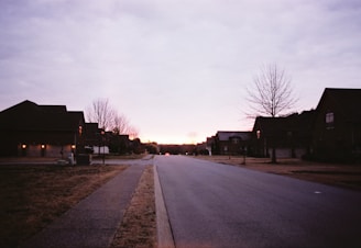 Sunset view of a quiet suburban street with houses.