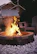 A modern stone fireplace glowing warmly in a stylish outdoor living space during sunset.