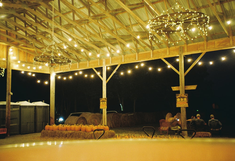 a barn filled with hay bales and lights