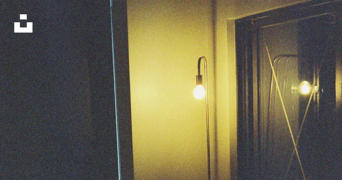 A dimly lit room with a bed and a door photo – Free Yellow Image on ...