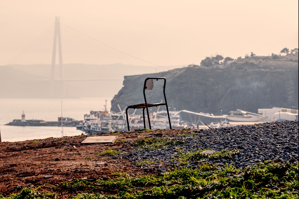 a chair sitting on top of a hill next to a body of water