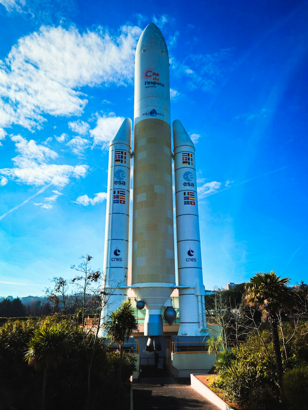 a large white rocket sitting on top of a lush green field