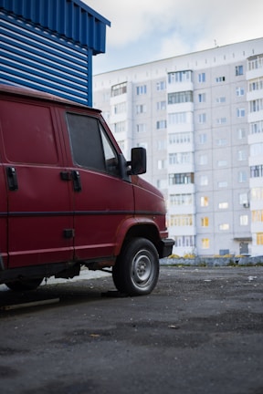 Bright red company van parked outside a client's home in Madrid.