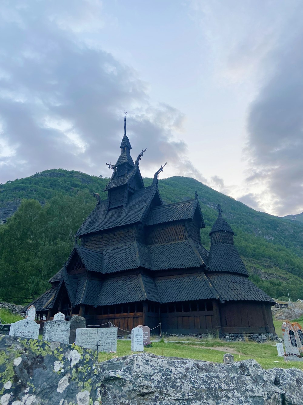 a wooden church with a steeple on top of a hill