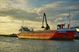 a large red boat floating on top of a body of water