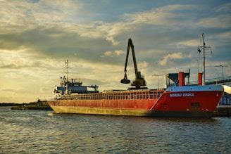 a large red boat floating on top of a body of water