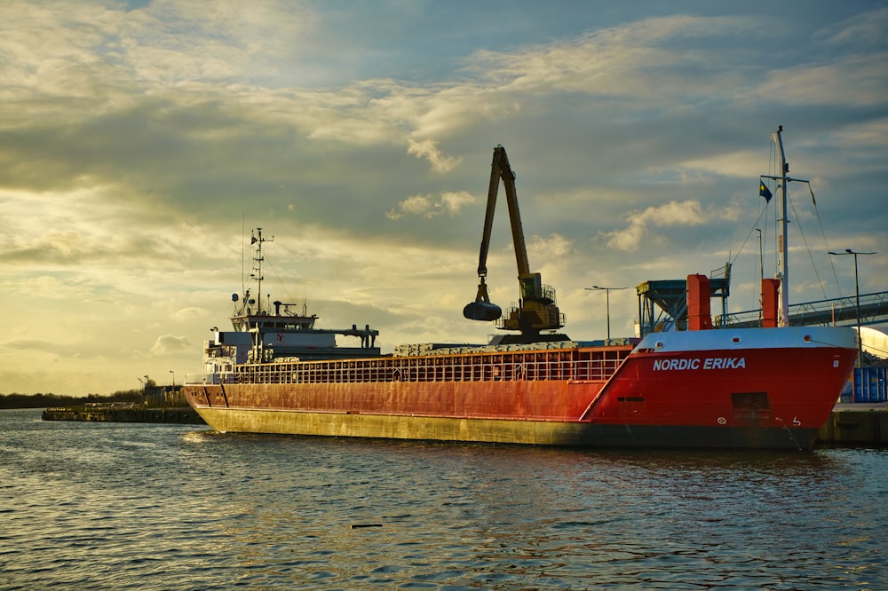 a large red boat floating on top of a body of water