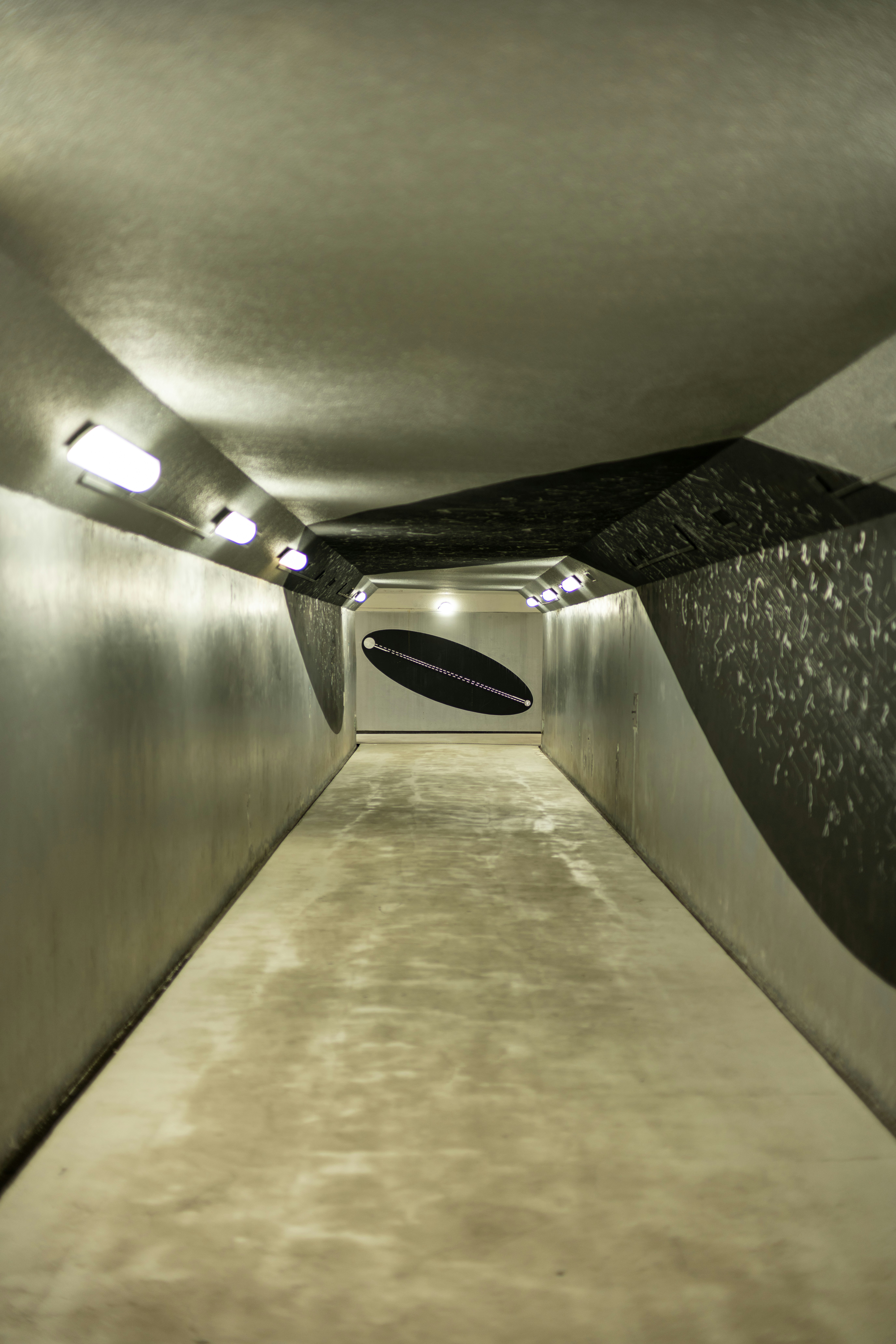 a long narrow tunnel with a surfboard on the floor