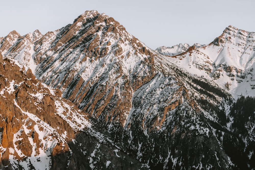 uma cordilheira coberta de neve com montanhas ao fundo