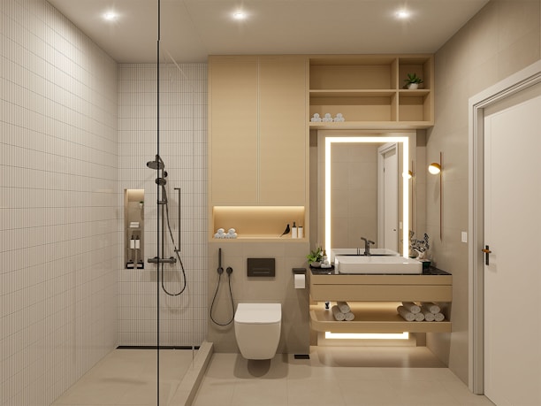 A modern, minimalistic bathroom featuring a walk-in shower with a rain shower head, a built-in shelf with toiletries, and a floating vanity with backlit mirror. The space includes a wall-mounted toilet, neatly stacked towels, potted plants, and recessed ceiling lights for a clean and organized look.