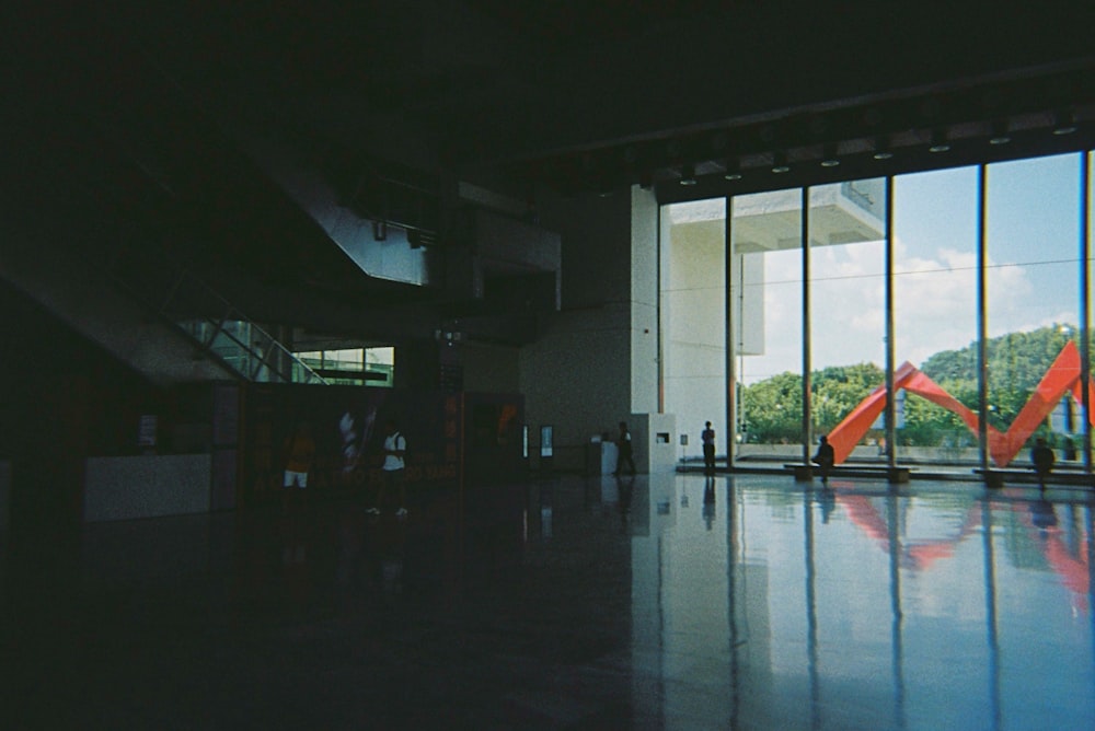 a group of people standing in front of a large window