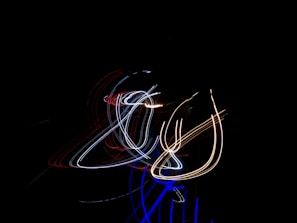 Abstract light trails swirling above a DJ’s turntables at an underground electronic music event.