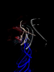 Flow of data streams visualized as vibrant light trails in office.