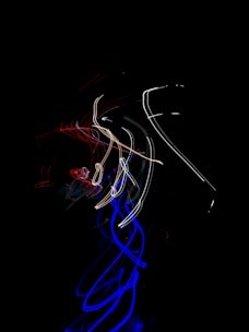 Flow of data streams visualized as vibrant light trails in office.